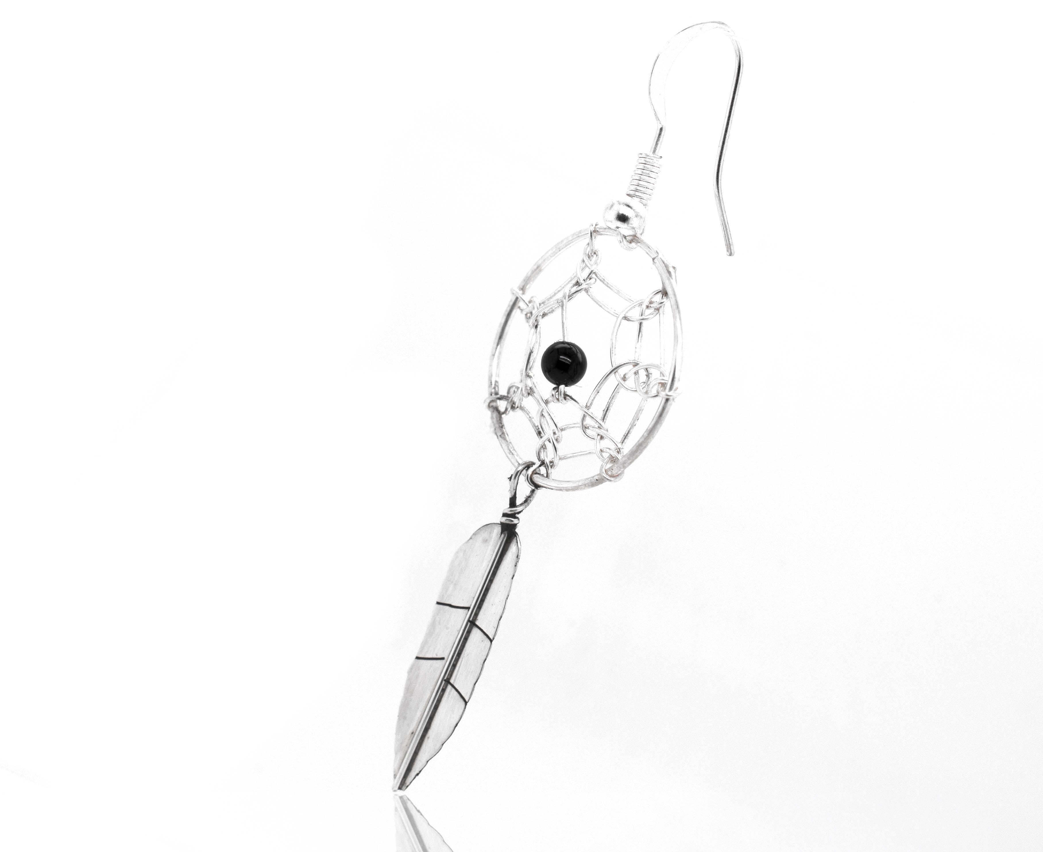 A Zuni Dreamcatcher earring with a turquoise stone, by Super Silver.