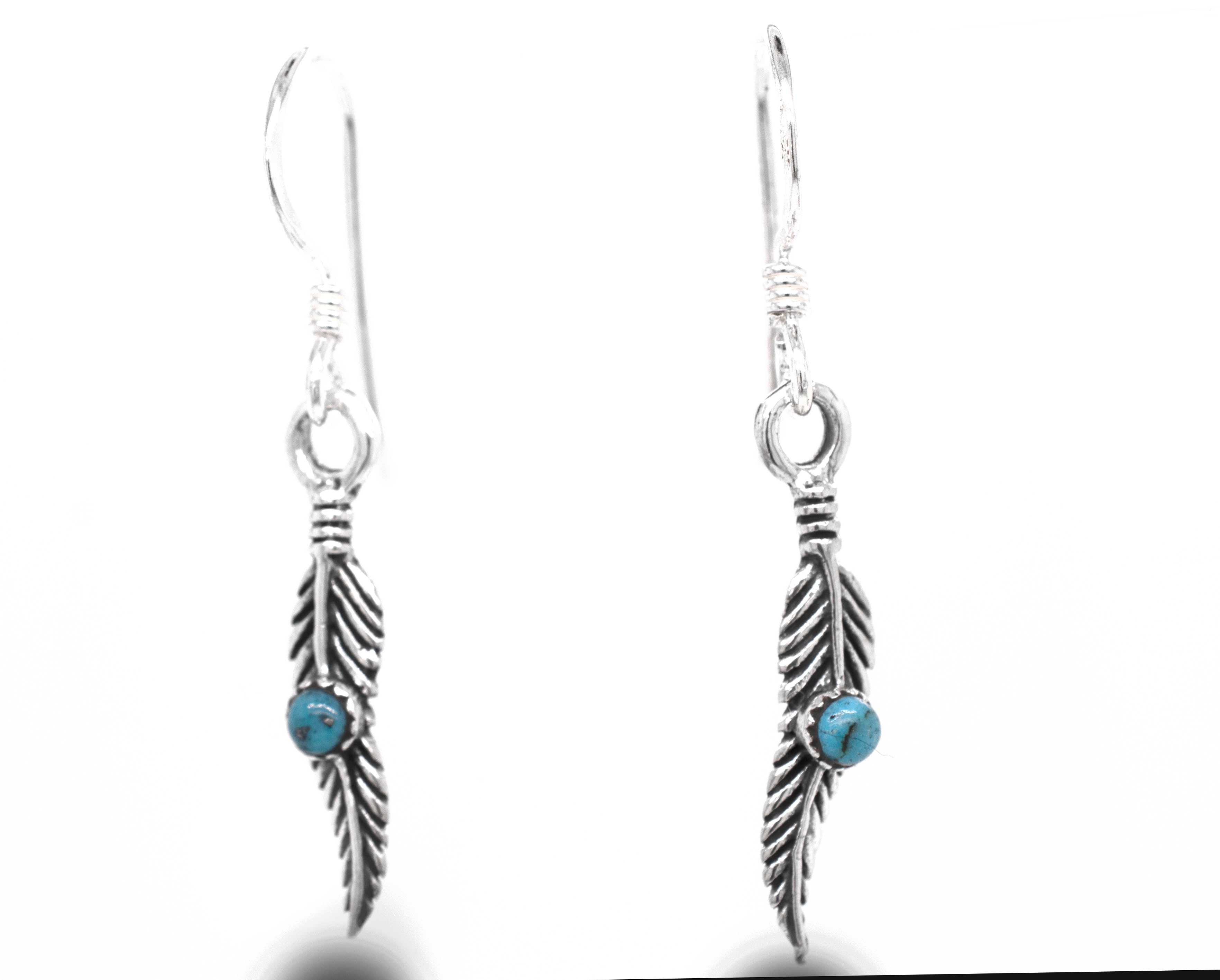A stunning pair of Super Silver delicate feather earrings adorned with vibrant turquoise stones.