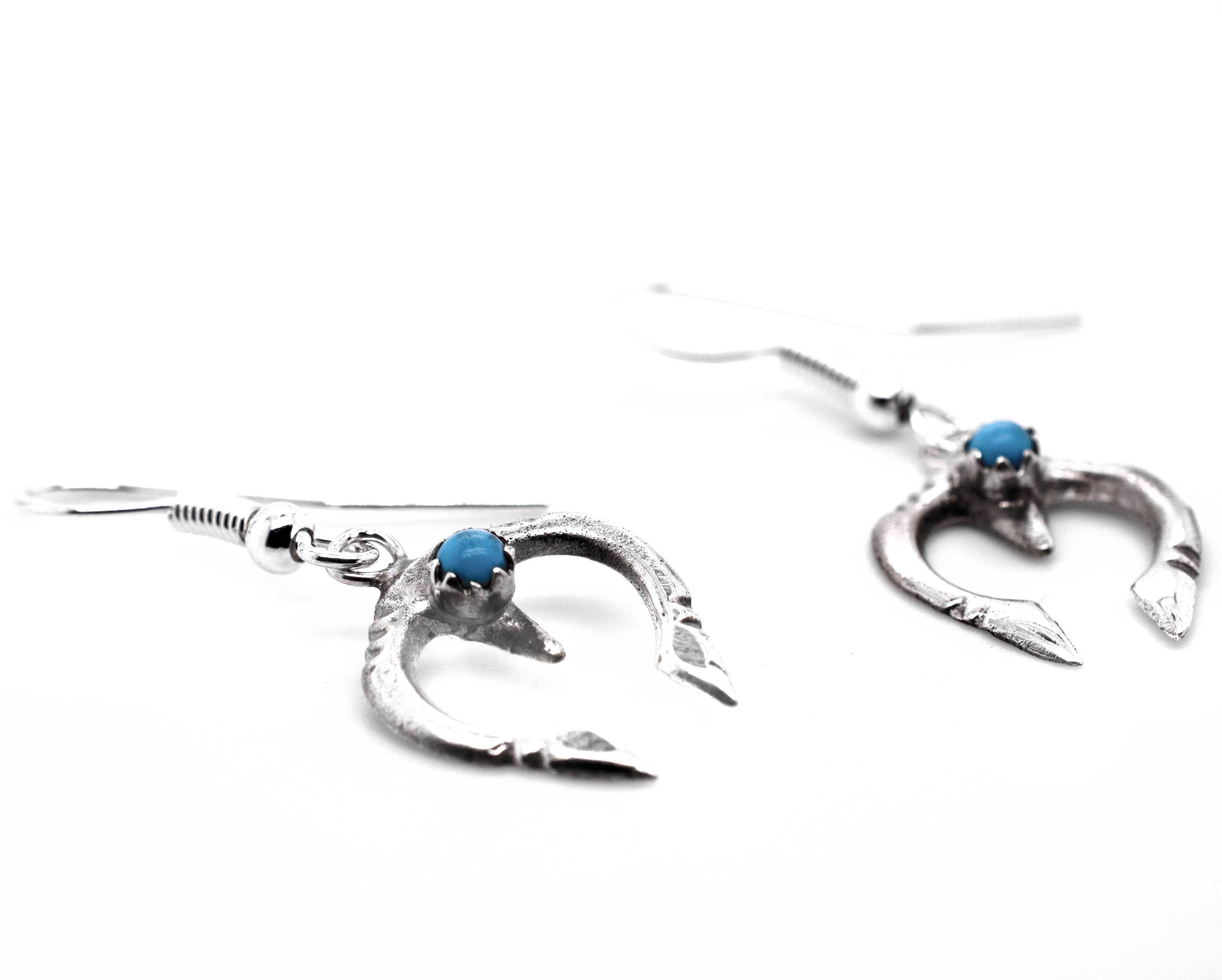 A pair of Super Silver Dainty Naja Turquoise Earrings with turquoise stones.