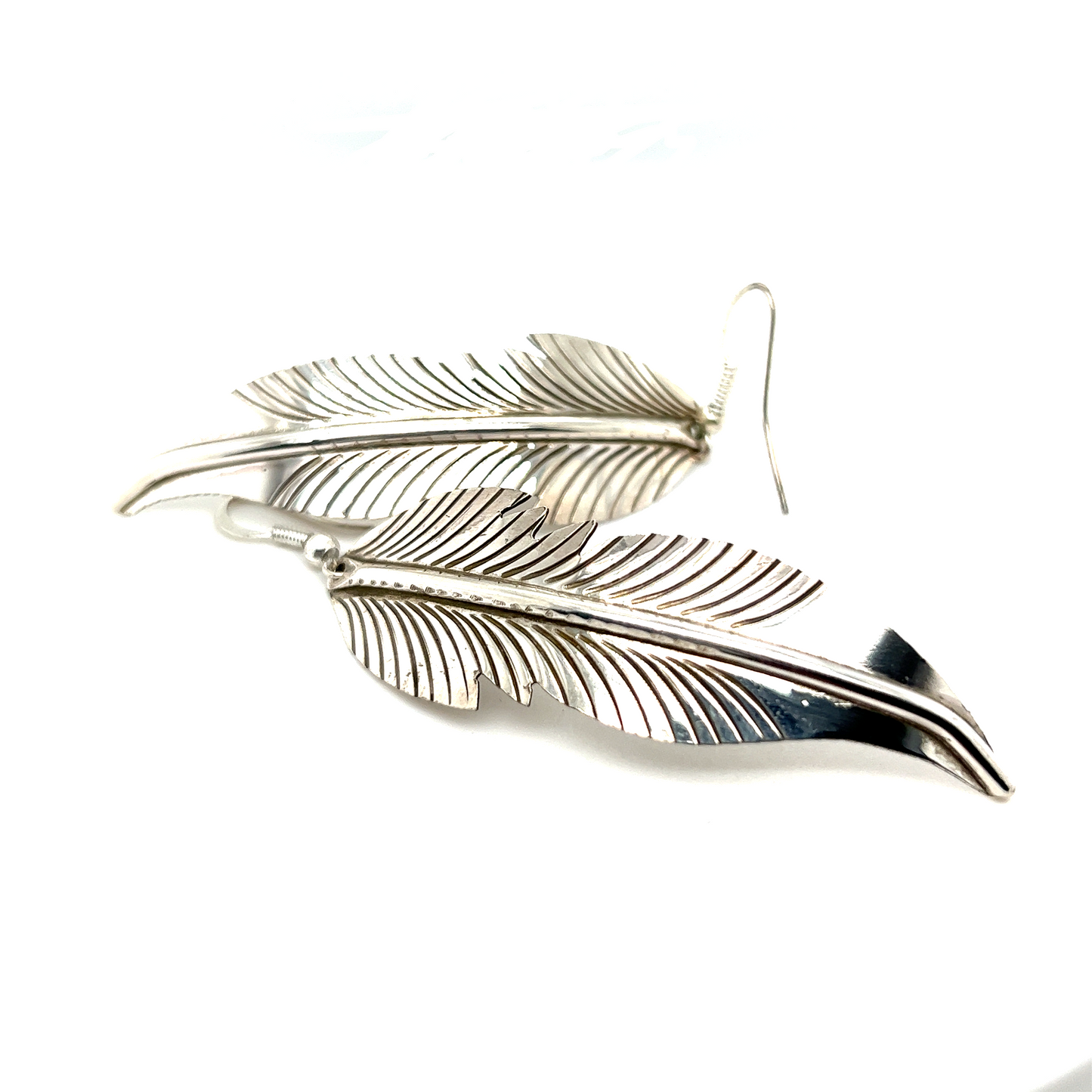 
                  
                    A pair of Super Silver Striking Native American Feather Earrings on a white surface.
                  
                