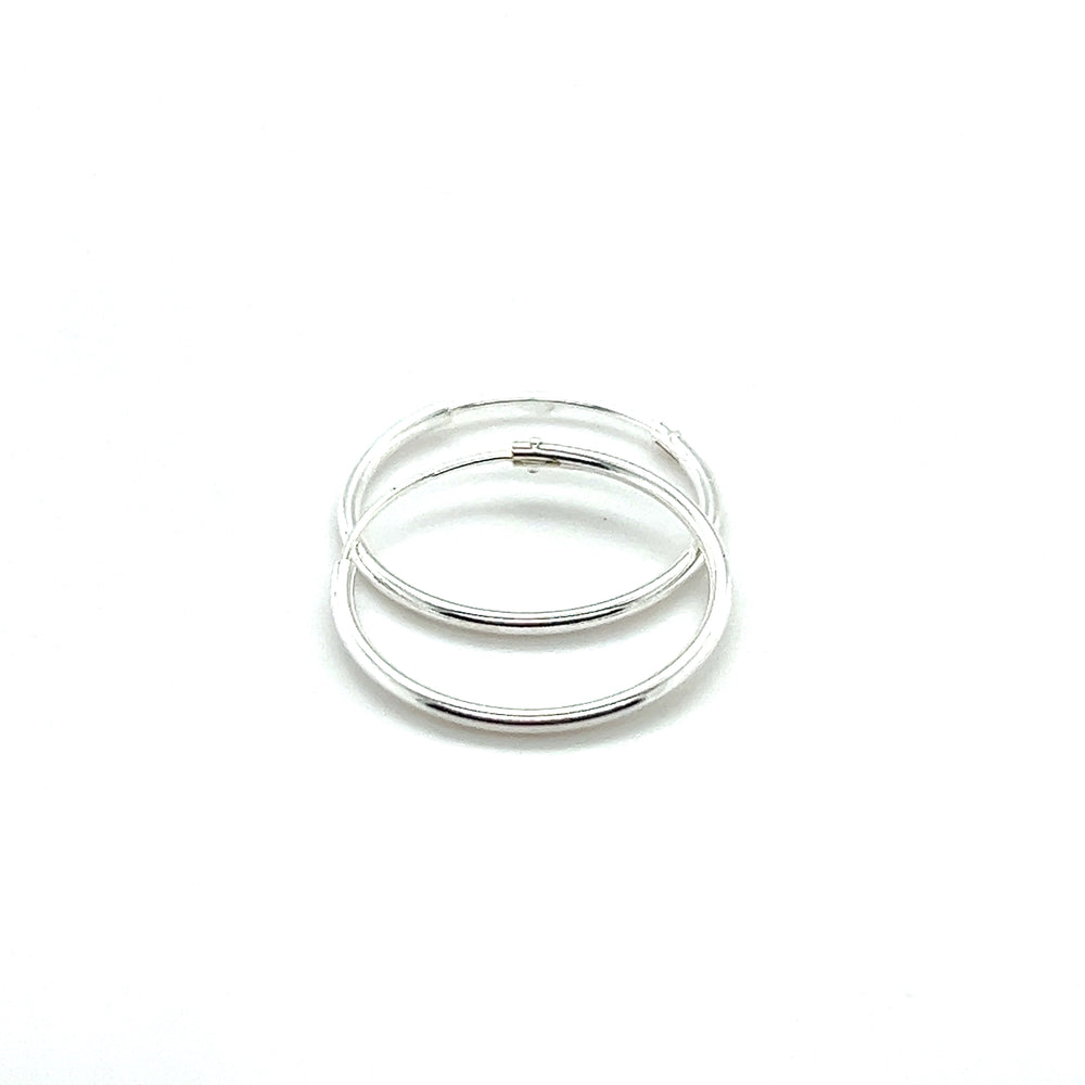 
                  
                    Two Super Silver 1.2mm Infinity Hoops on a white background.
                  
                