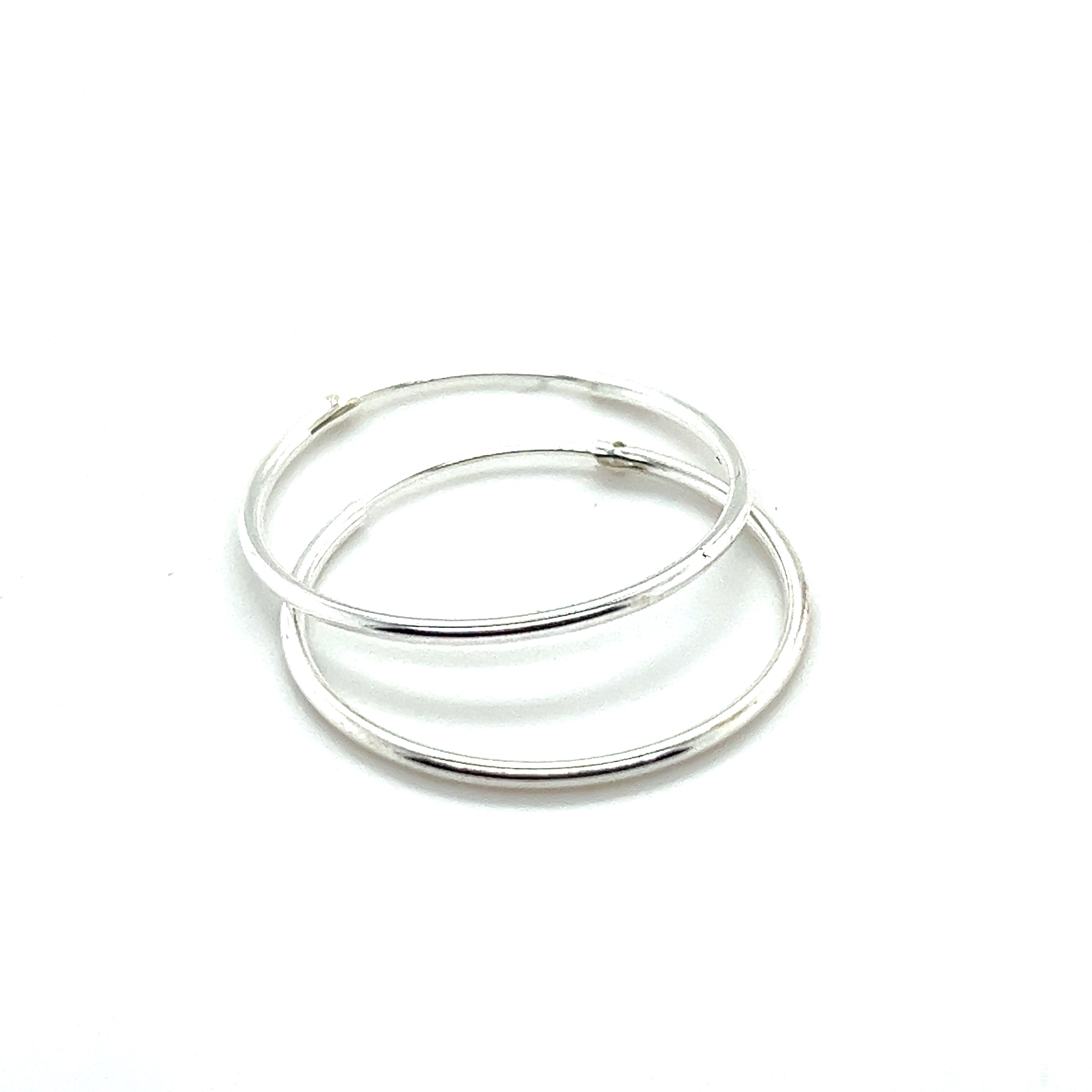 The 1.2mm Infinity Hoops, crafted from .925 Sterling Silver, elegantly rest on a plain white background, showcasing their exquisite infinity hoop design.