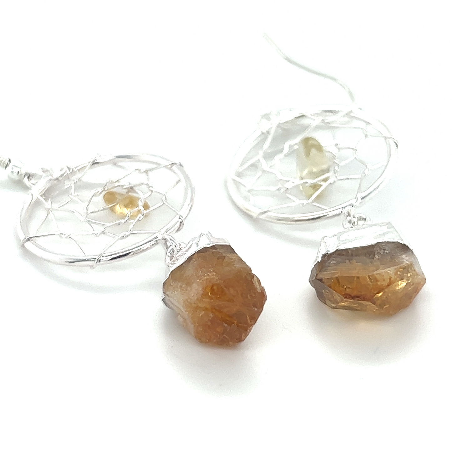 
                  
                    A pair of Raw Crystal Dream Catcher Earrings from Super Silver with a yellow gemstone and a silver wire.
                  
                