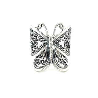 
                  
                    A minimalist large silver butterfly ring on a white background.
                  
                
