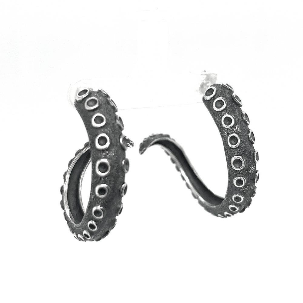 
                  
                    A pair of Super Silver Edgy Octopus Tentacle Hoop Earrings on a white background, exuding oceanic charm.
                  
                