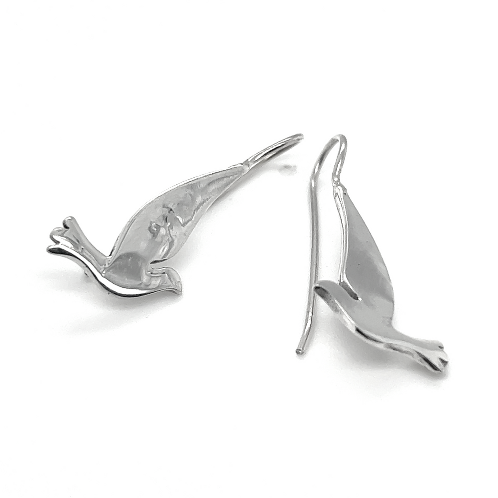 A pair of Super Silver silver dove earrings on a white background, symbolizing peace.