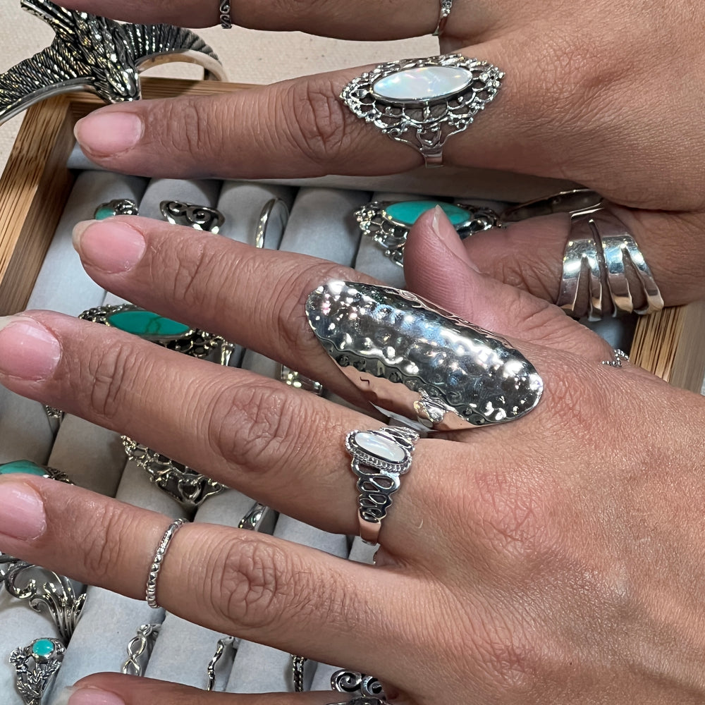 
                  
                    A woman's hands adorned with Super Silver's Statement Hammered Rings, including a silver hammered ring, delicately placed in a box.
                  
                