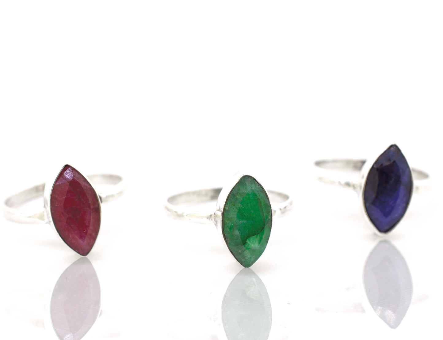 Three Simple Marquise Shaped Gemstone Rings with cabochon stones on a white surface.