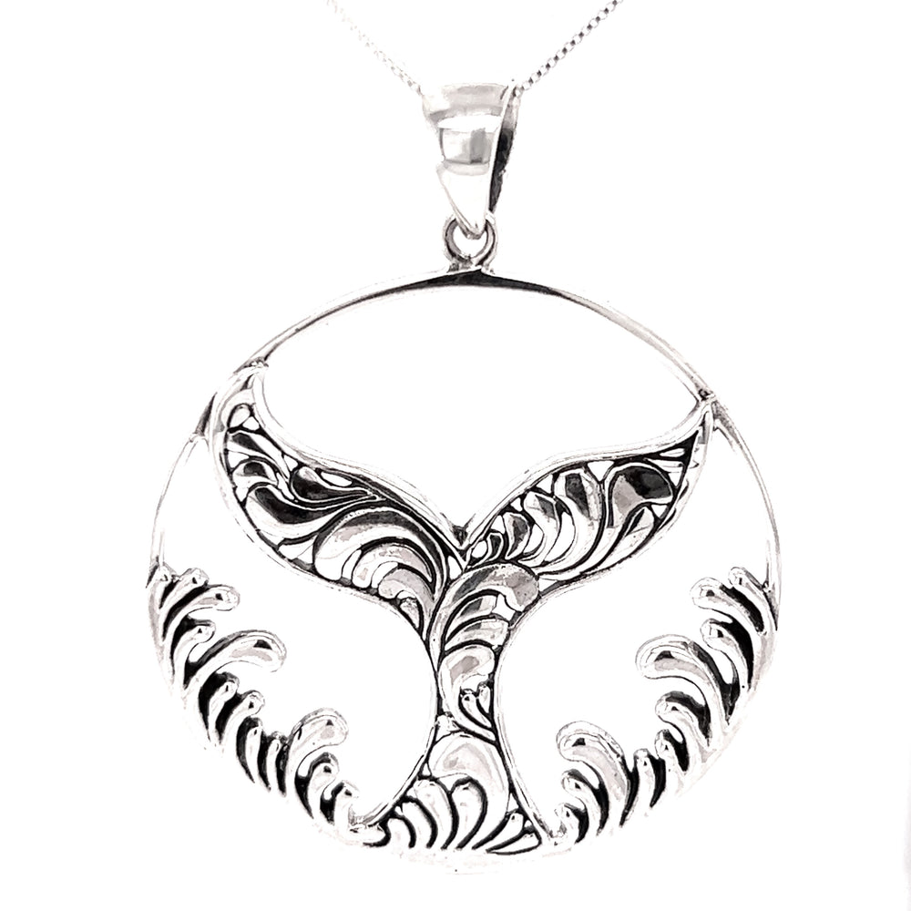 
                  
                    A handcrafted Magnificent Whale Tail Pendant with Waves, exuding a beachy charm as it hangs on a silver chain.
                  
                