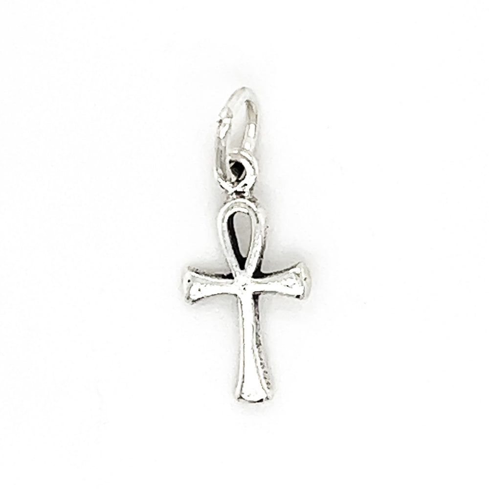 A small Enchanting Tiny Ankh Charm with a loop at the top for attaching to a chain or necklace. This beautifully crafted Enchanting Tiny Ankh Charm, an ancient Egyptian symbol, features a teardrop-shaped loop above a T-shaped cross.