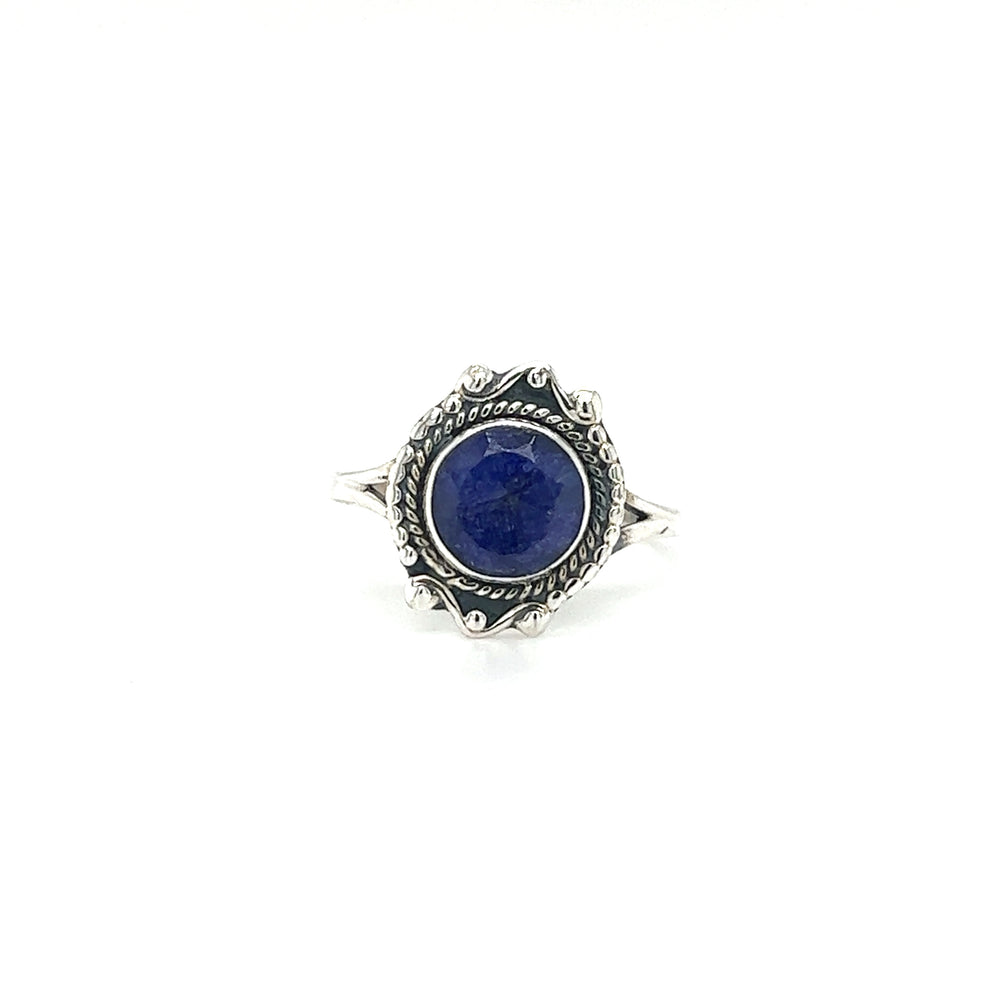 
                  
                    A Round Gemstone Ring With Vintage Setting with intricate details, this piece features a round blue gemstone in the center. Crafted from .925 Sterling Silver, it exudes bohemian sophistication, set elegantly against a white background.
                  
                