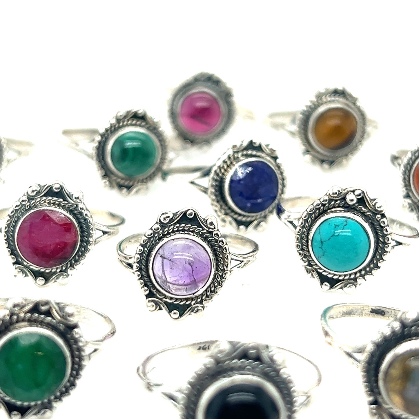 A collection of Round Gemstone Rings With Vintage Setting with various inlays, including amethyst, turquoise, and others, displayed in rows on a white background. Perfect for those who appreciate Bohemian jewelry and the timeless appeal of sterling silver rings.