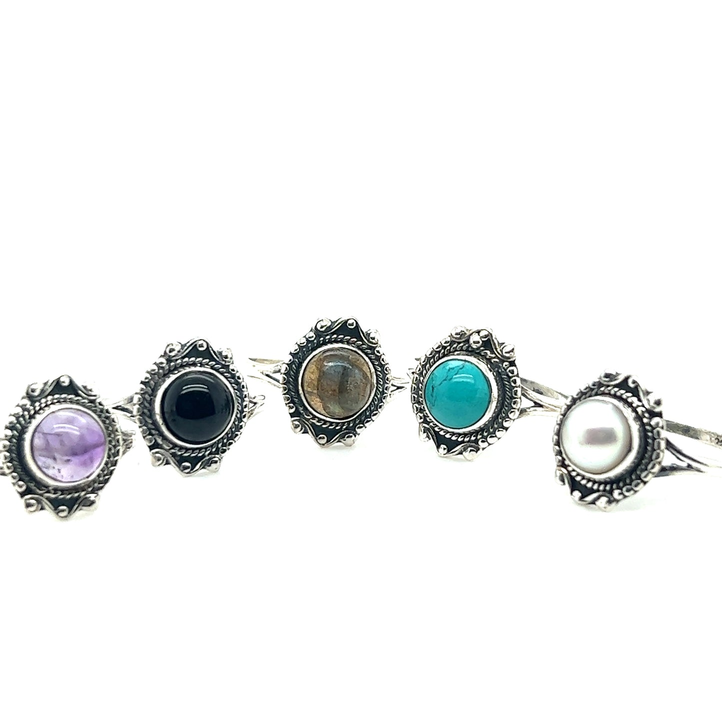 Five Round Gemstone Rings With Vintage Setting featuring amethyst, onyx, labradorite, turquoise, and pearl are set in intricate metal settings. These beautiful pieces of bohemian jewelry are displayed in a row on a white background.