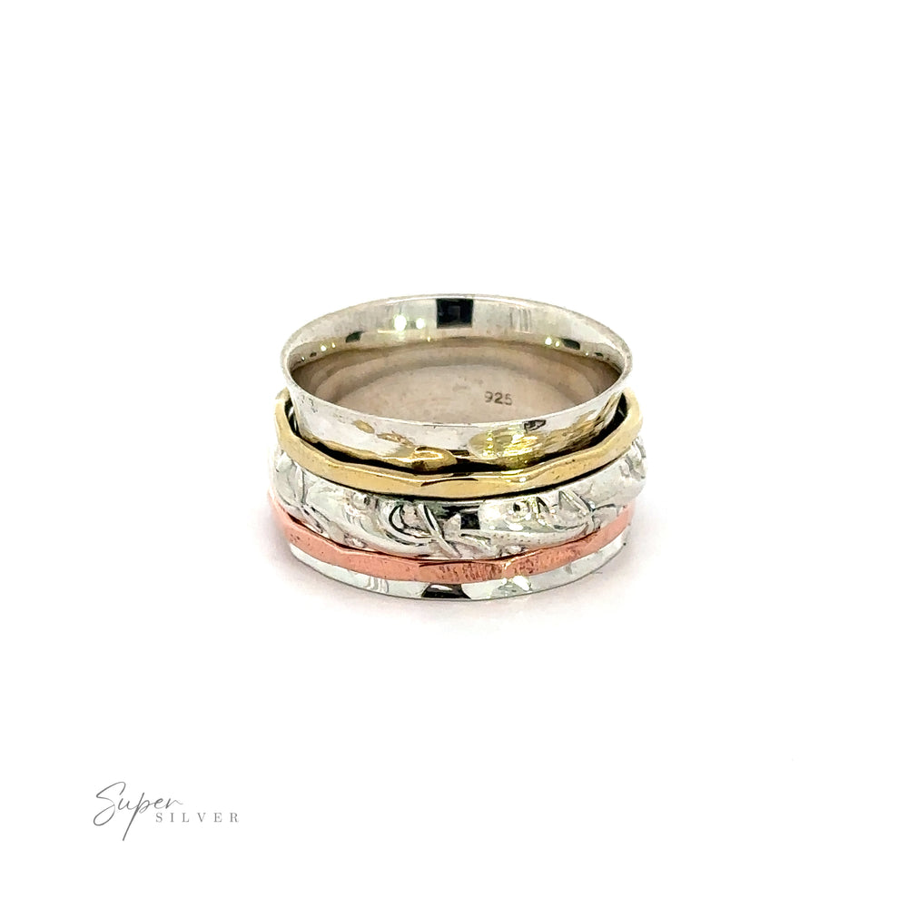 
                  
                    A stack of Handmade Spinner Rings with a Filigree Pattern Band in silver and gold, featuring a hammered tricolor design, beautifully displayed on a white background.
                  
                