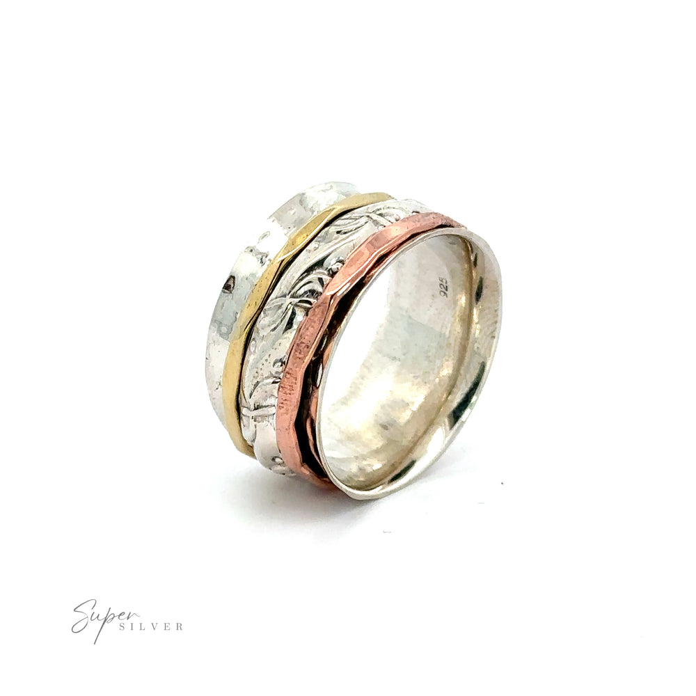 A Handmade Spinner Ring with a Filigree Pattern Band in silver and rose gold, showcased on a simple white background.
