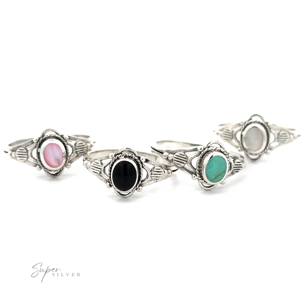 Four Fancy Oval Inlay Stone Rings with different colored stones, including onyx, on a white background.
