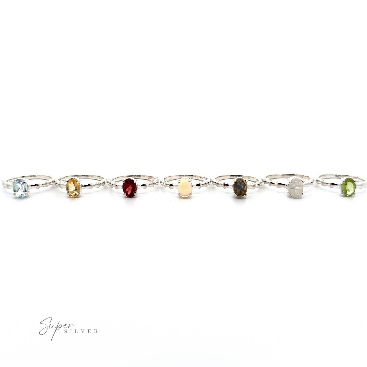 
                  
                    A Pronged Oval Gemstone Ring with Textured Band with various colored stones linked together on a white background.
                  
                