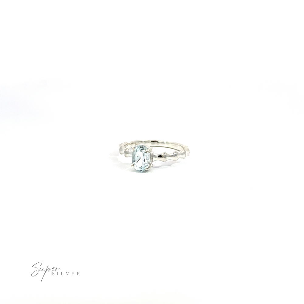 
                  
                    Pronged Oval Gemstone Ring with Textured Band with a single oval Blue Topaz on a white background.
                  
                