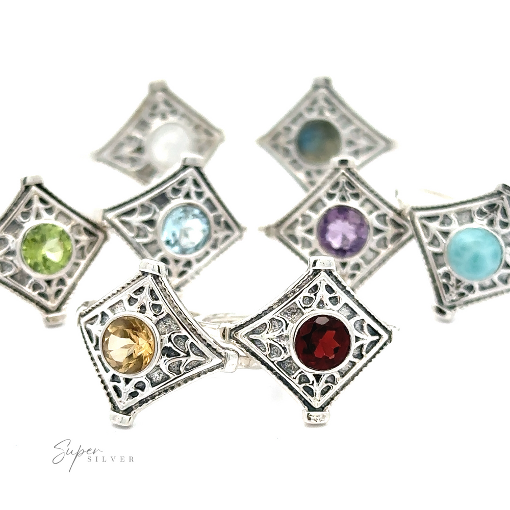 A collection of ornate Intricate Diamond Sterling Silver pendant frames, each inset with a different colored gemstone, displayed against a white background.