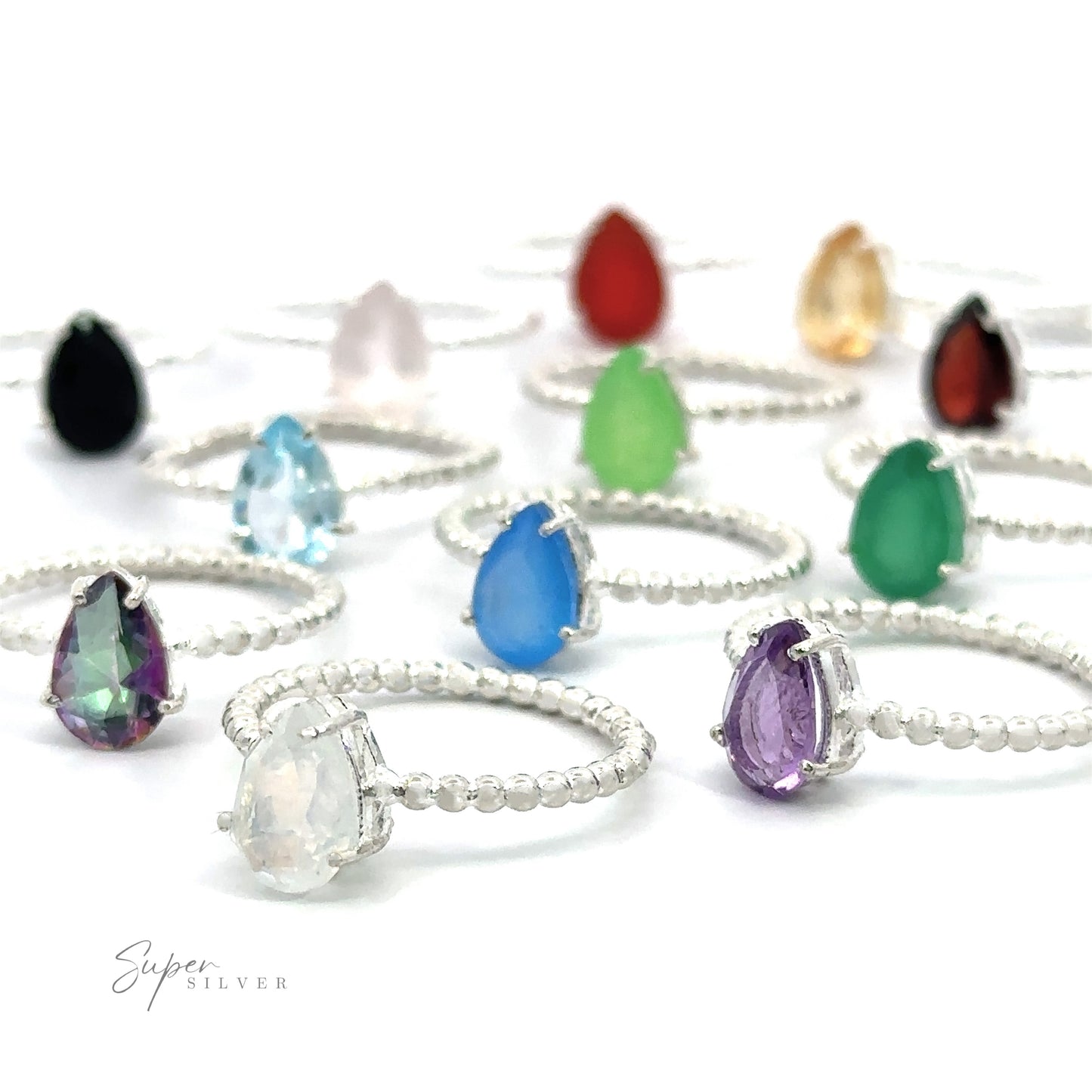 Assortment of Vibrant Teardrop Gemstone Rings with Beaded Bands in prong settings on a white surface.
