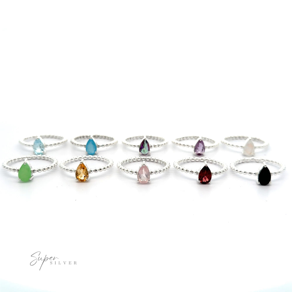 
                  
                    A collection of Sparkling Teardrop Gemstone on Beaded Band rings with various colored teardrop gemstones, displayed against a white background.
                  
                
