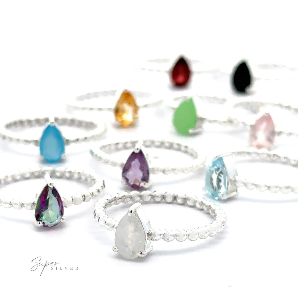 Sparkling Teardrop Gemstone on Beaded Band rings displayed against a white background.