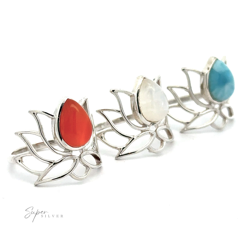 Three Online Exclusive Teardrop Stone Lotus Rings, each with a different colored teardrop gemstone—red, white, and blue—in a row on a white background.