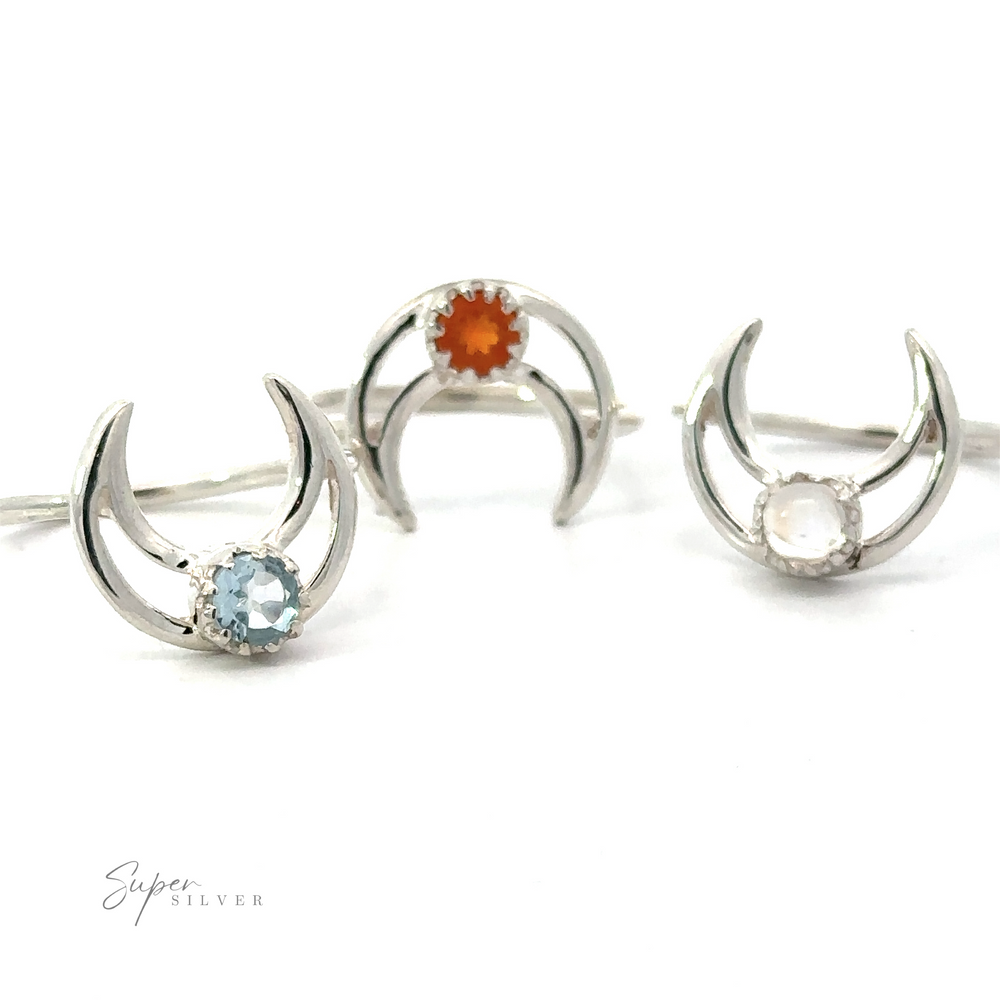 Three Online Exclusive Gemstone Moon Outline Rings, each set with a different colored gem: orange, blue, and pink, displayed on a white background.