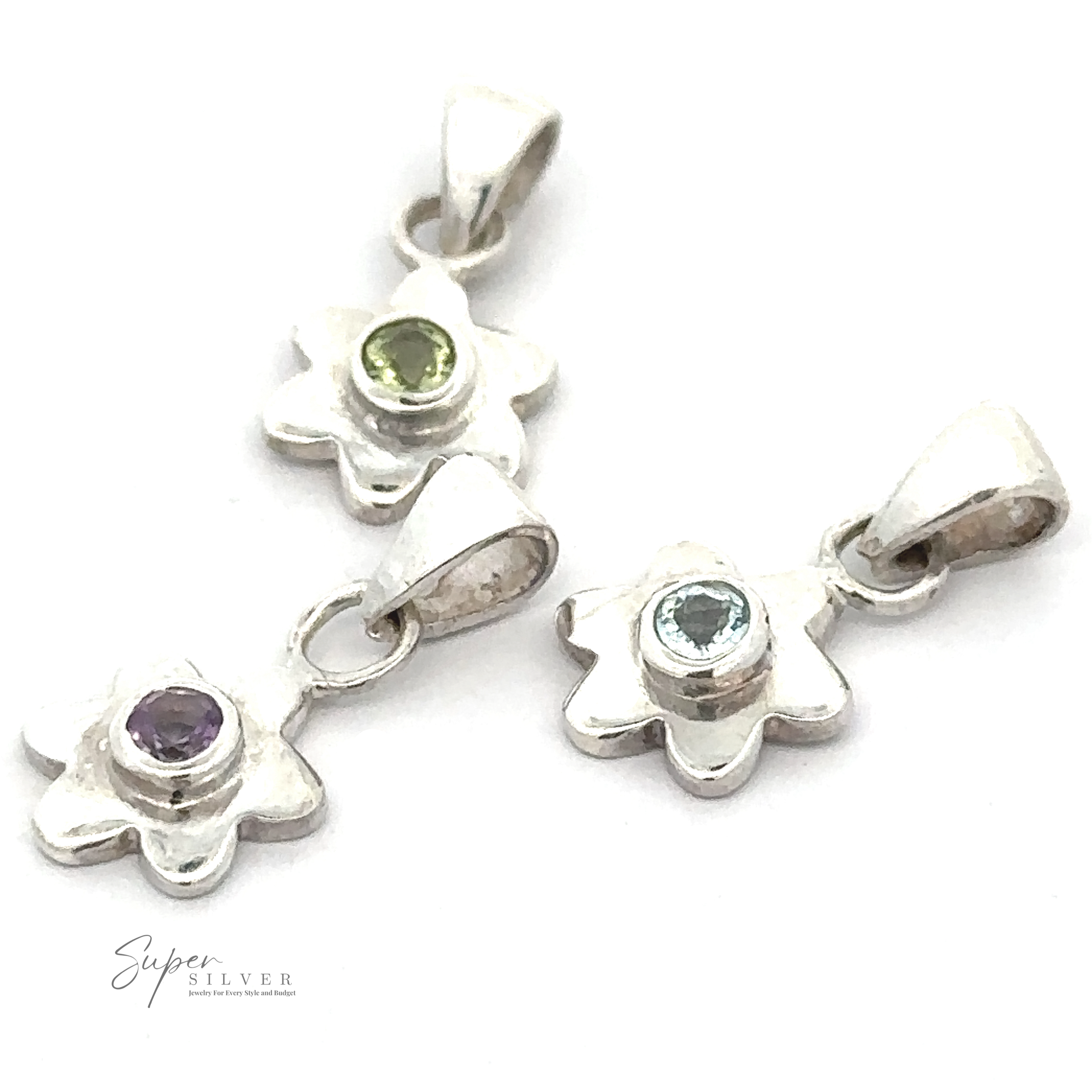 Three Tiny Gemstone Flower Pendants, each with a unique gemstone center, arranged on a white background. The gemstones are purple, light green, and light blue.
