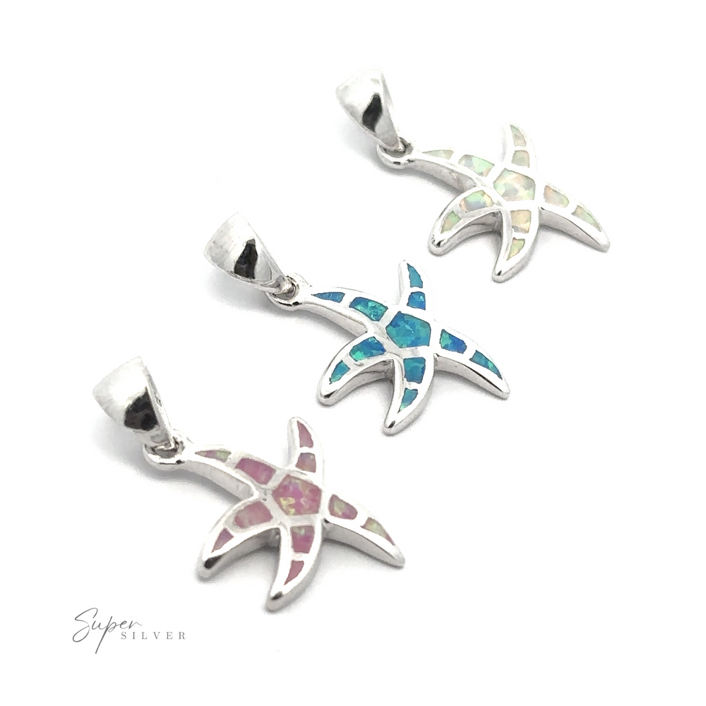 Three Lab-Created Opal Sea Star Pendants with multicolored inlays, featuring pink, blue, and green accents, are arranged diagonally on a white background. Their oceanic magic shines brightly, evoking the beauty of lab-created opal.