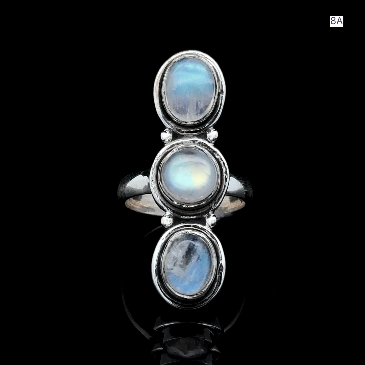 
                  
                    Triple Moonstone Ring crafted from sterling silver, showcases three stacked oval cabochons set on a polished black backdrop, exuding goddess energy.
                  
                