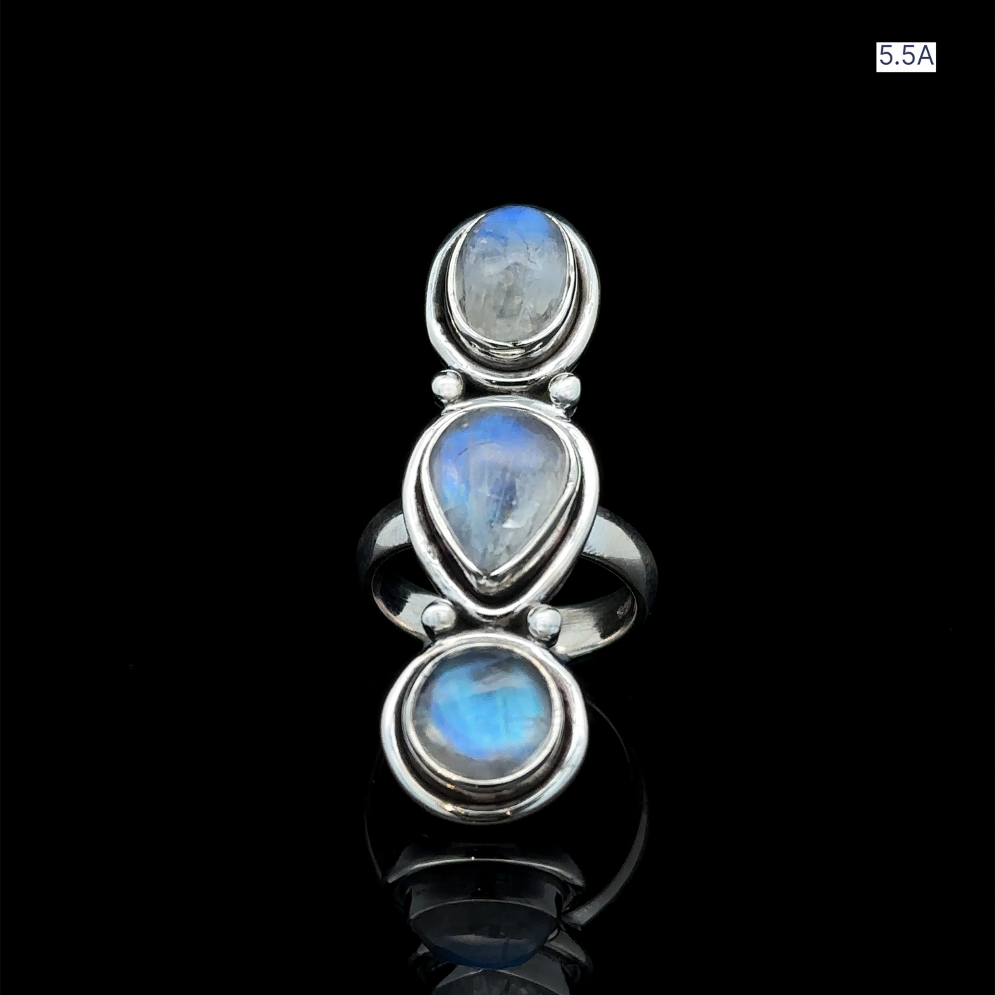 
                  
                    The Triple Moonstone Ring showcases three blue moonstone gems arranged vertically on a sleek black background, channeling goddess energy.
                  
                