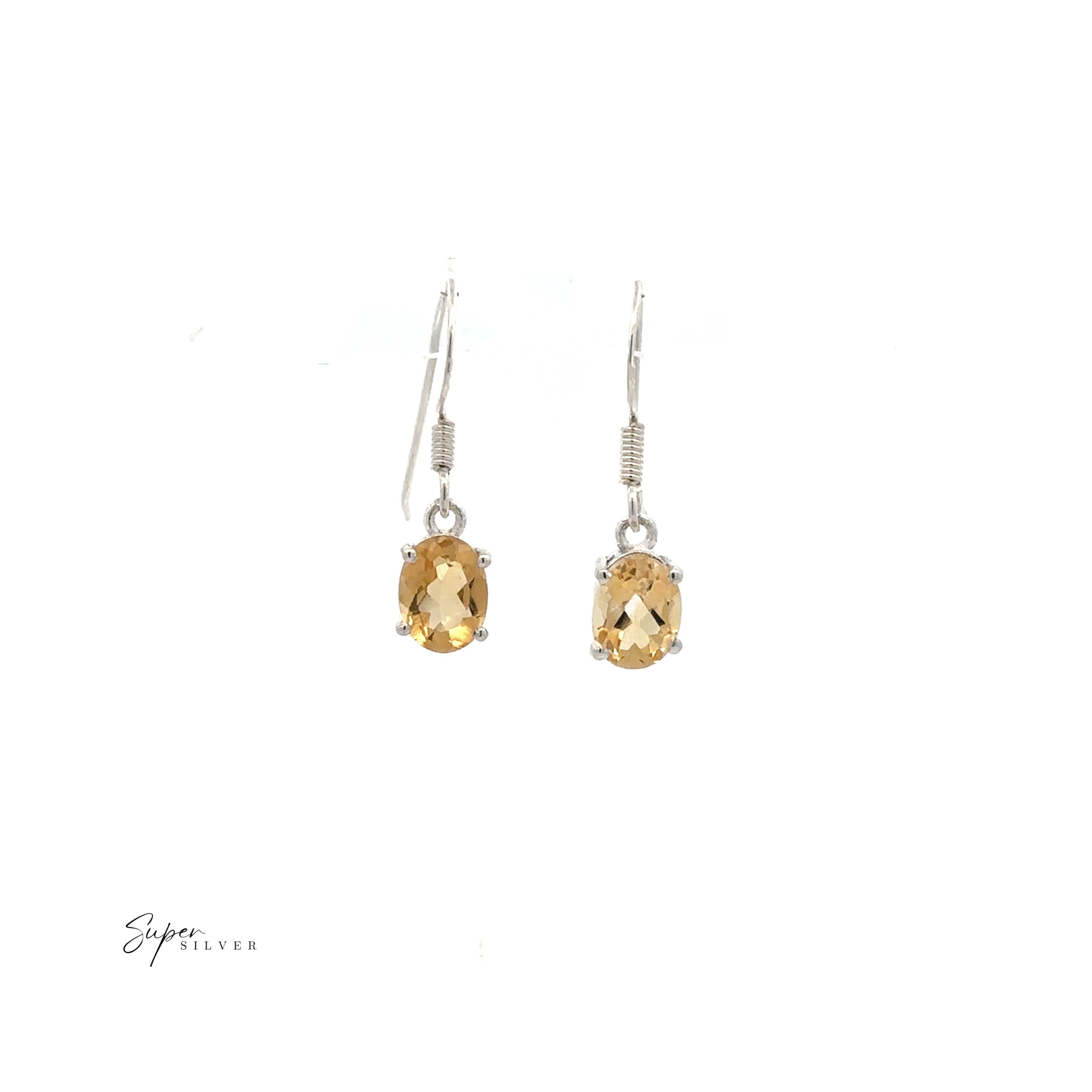 The Brilliant Oval Gemstone Earrings are sterling silver with prong-set, oval-cut yellow gemstones, shown against a plain white background.