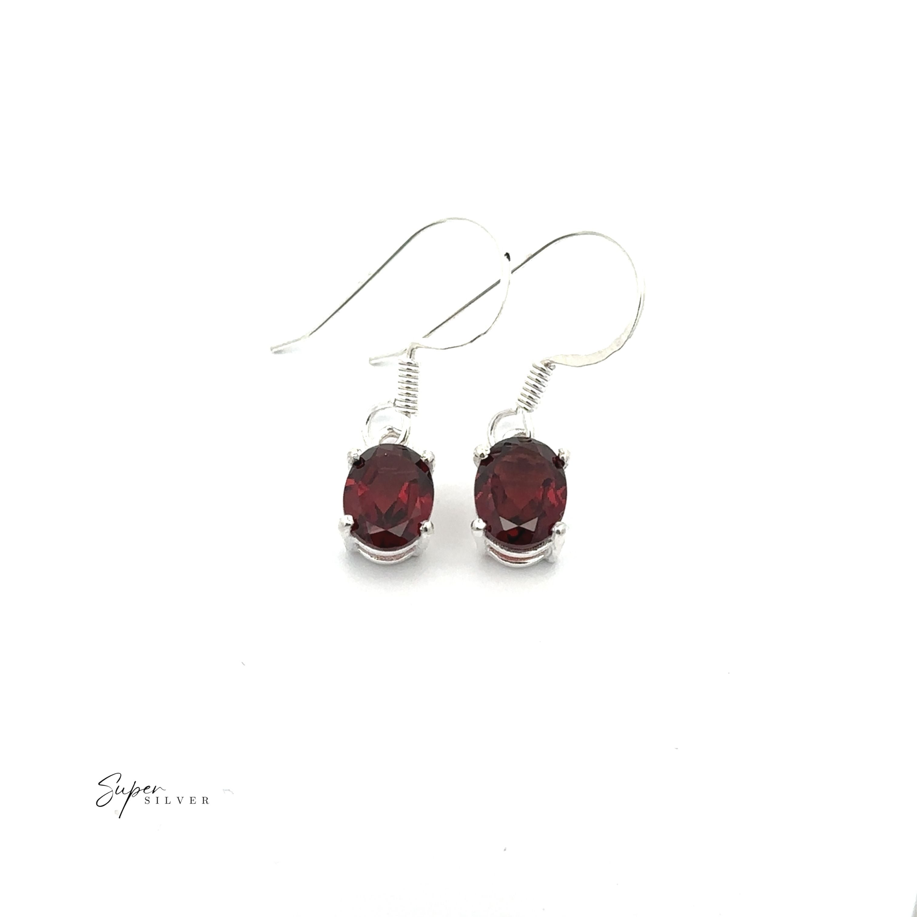 Brilliant Oval Gemstone Earrings: sterling silver hook earrings with oval red gemstones, showcased on a white background—elegant and perfect for any occasion.