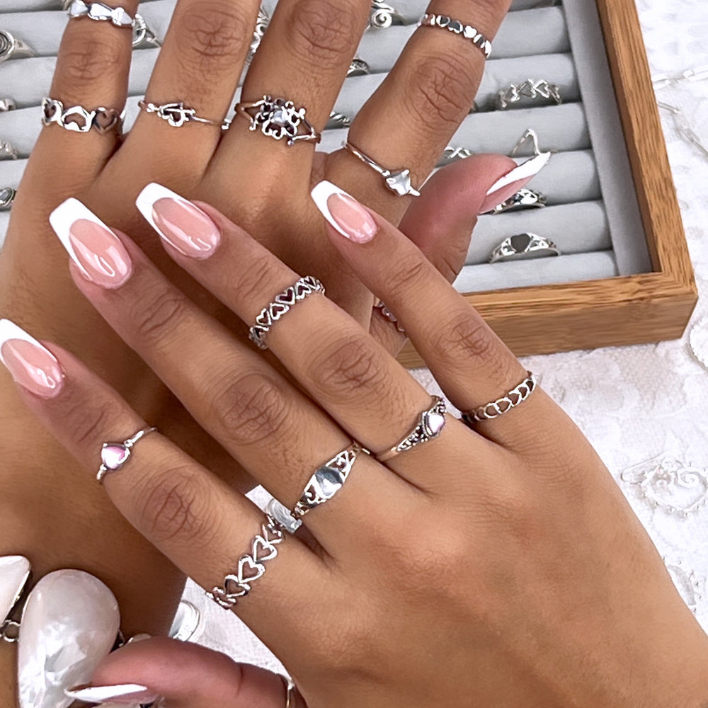 
                  
                    A woman's hand adorned with everyday wear rings, including a Horizontal Cut-Out Heart Band. The rings are perfect for stacking and adding an extra touch of style to any outfit.
                  
                