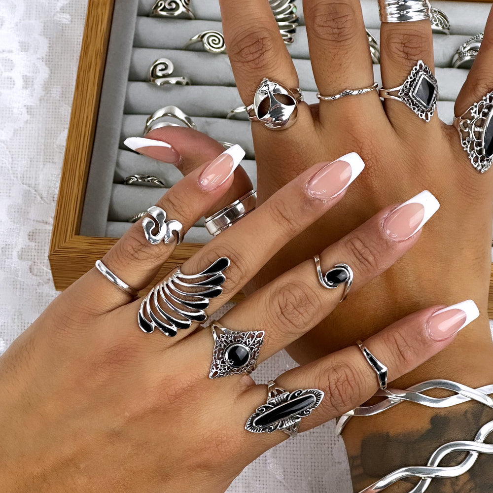 
                  
                    A fashionable woman's hand adorned with cosmic journey rings and a Silver Alien Head Ring.
                  
                