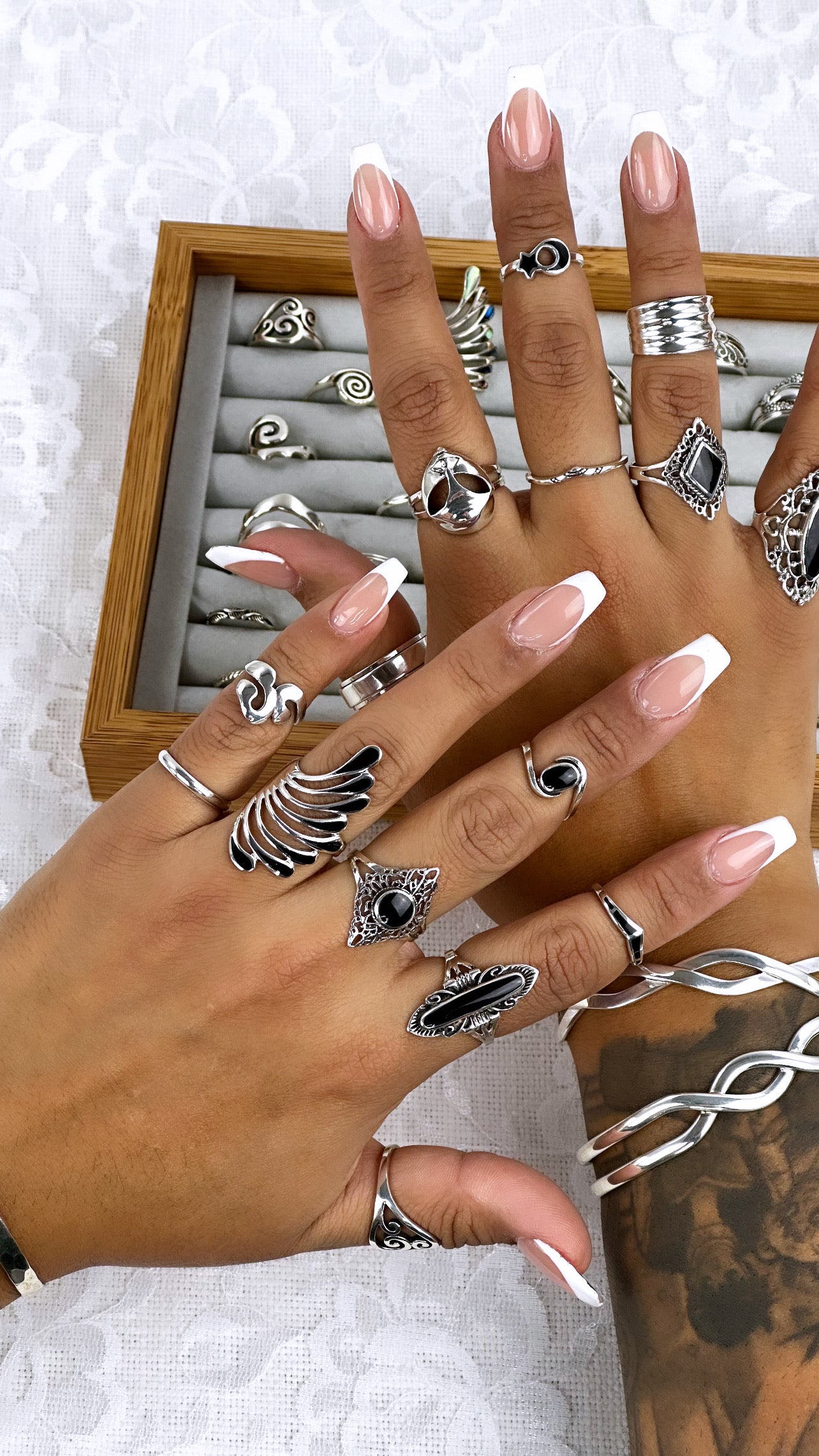 
                  
                    A fashionable woman's hand adorned with cosmic journey rings and a Silver Alien Head Ring.
                  
                