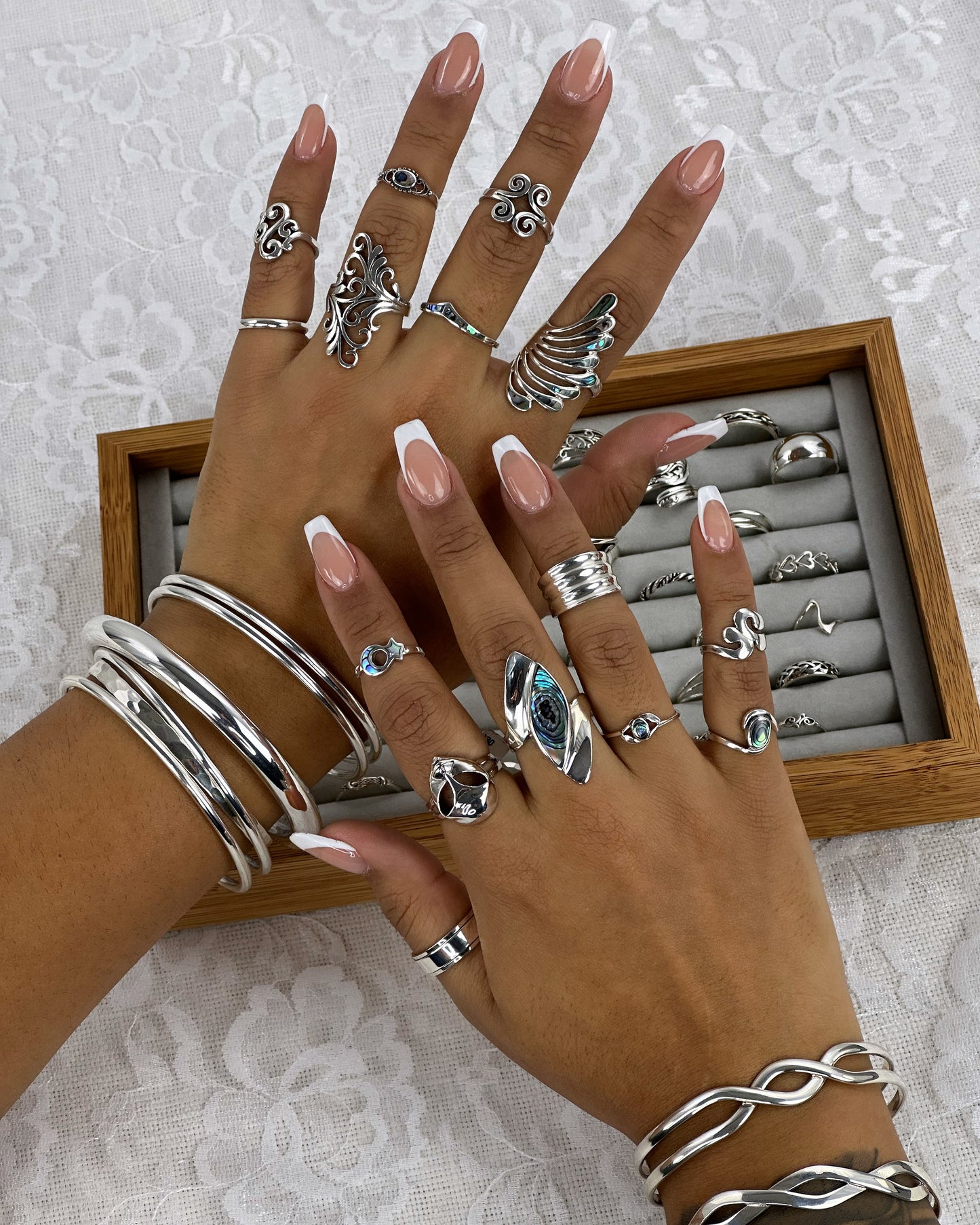 
                  
                    A woman's hands with Modern Marquise Shaped Inlaid Shell rings in a wooden box.
                  
                