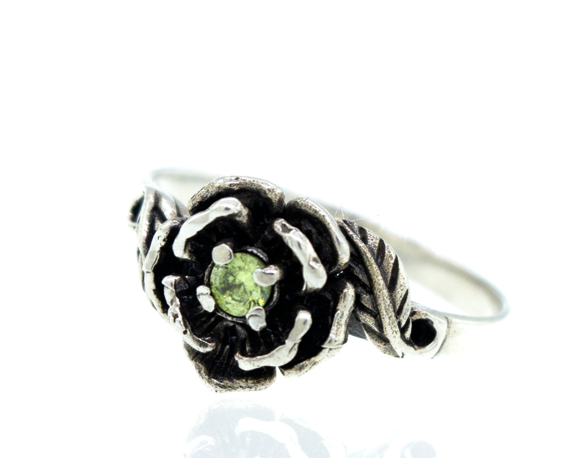 Rose Ring With Cubic Zirconia Stone featuring an intricately designed flower with a small green gemstone at its center.