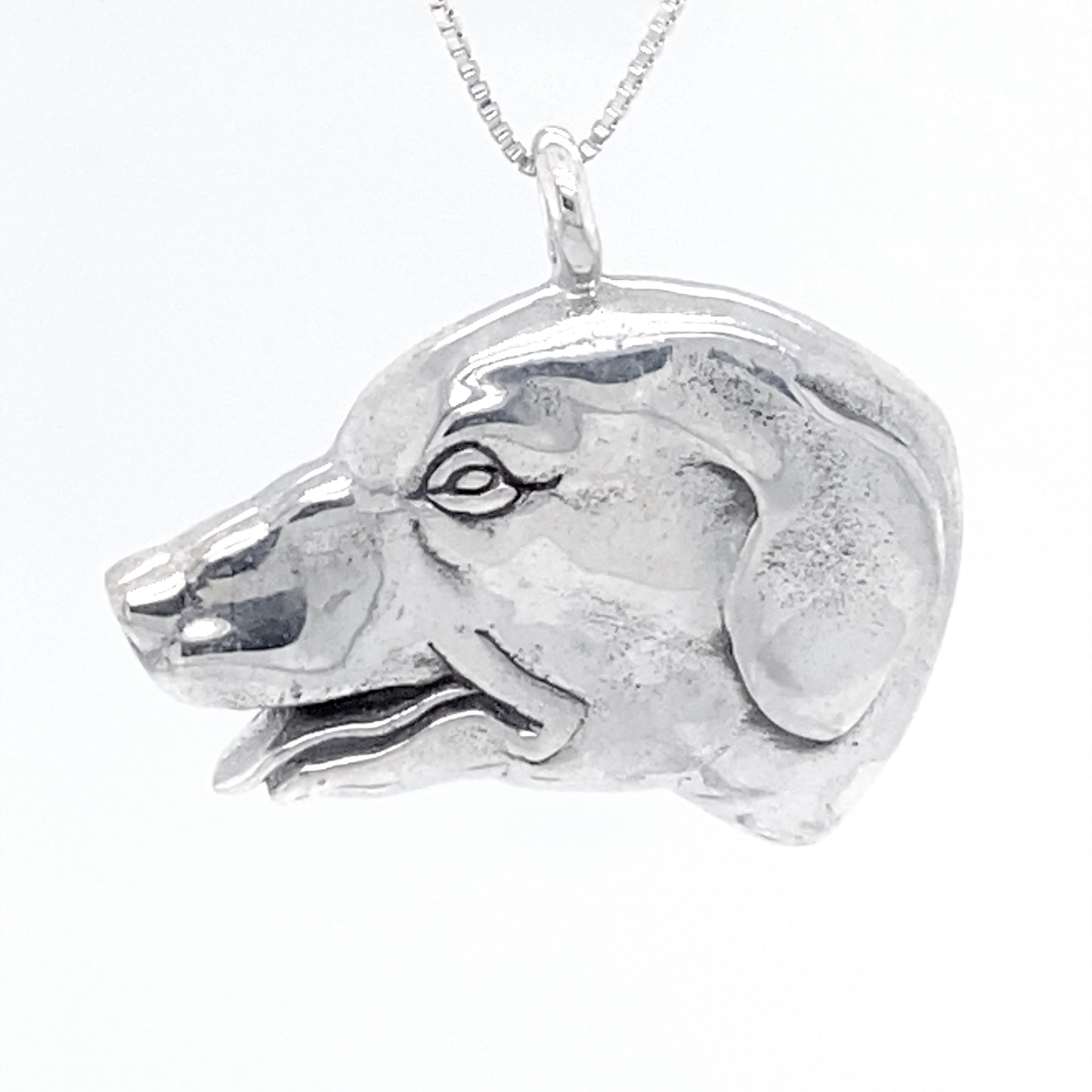 A Dog Head Pendant shaped like the head of a dog, showing detailed facial features and ears, is suspended from a thin chain—an ideal dog lover gift.