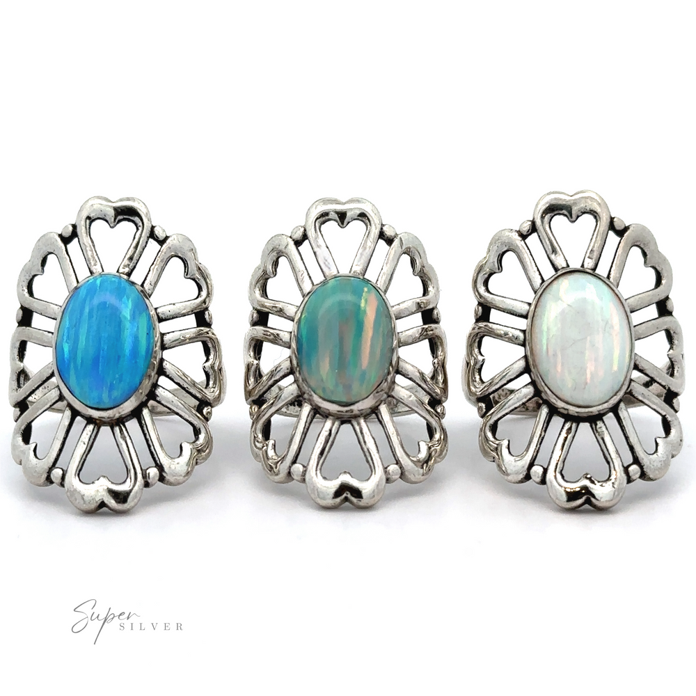 
                  
                    Three American Made Opal Flower Rings with Heart Shaped Petals featuring blue and green opals are displayed in a row against a white background. Handcrafted in America, these exquisite pieces showcase artisanal craftsmanship.
                  
                