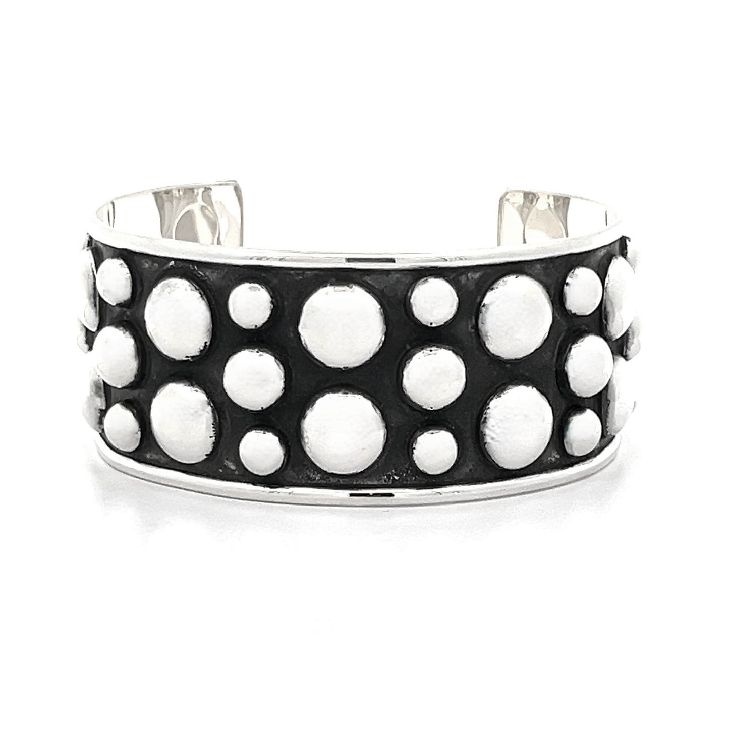 
                  
                    The Unique Ball Studded Cuff is a silver bracelet with a black background, adorned with a bold pattern of white circular designs, making it the perfect statement piece for those with a rebellious vibe.
                  
                