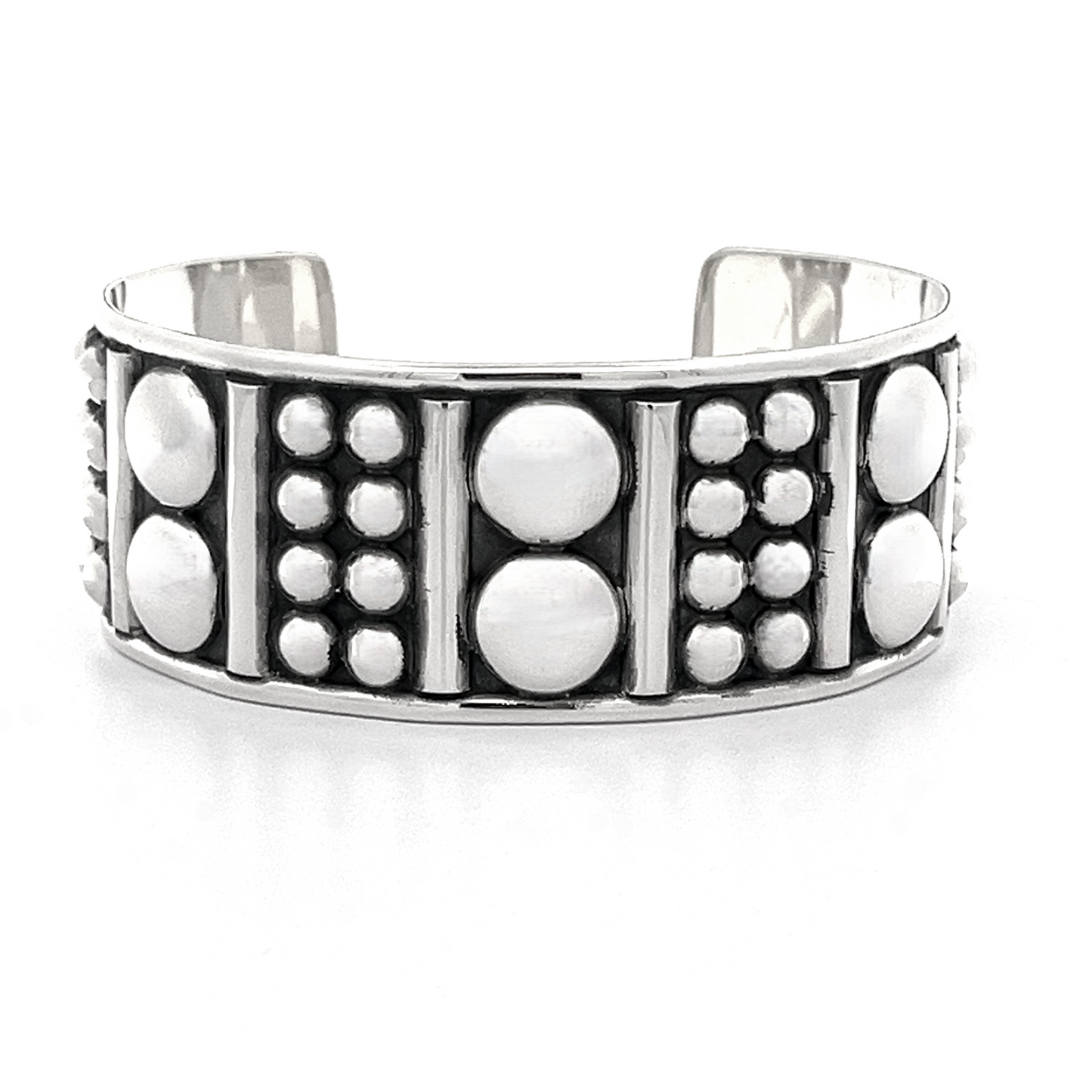 
                  
                    Introducing the Bold Ball Patterned Cuff: a sterling silver bracelet with an edgy design that features striking raised geometric patterns alongside a mix of large and small circular motifs.
                  
                