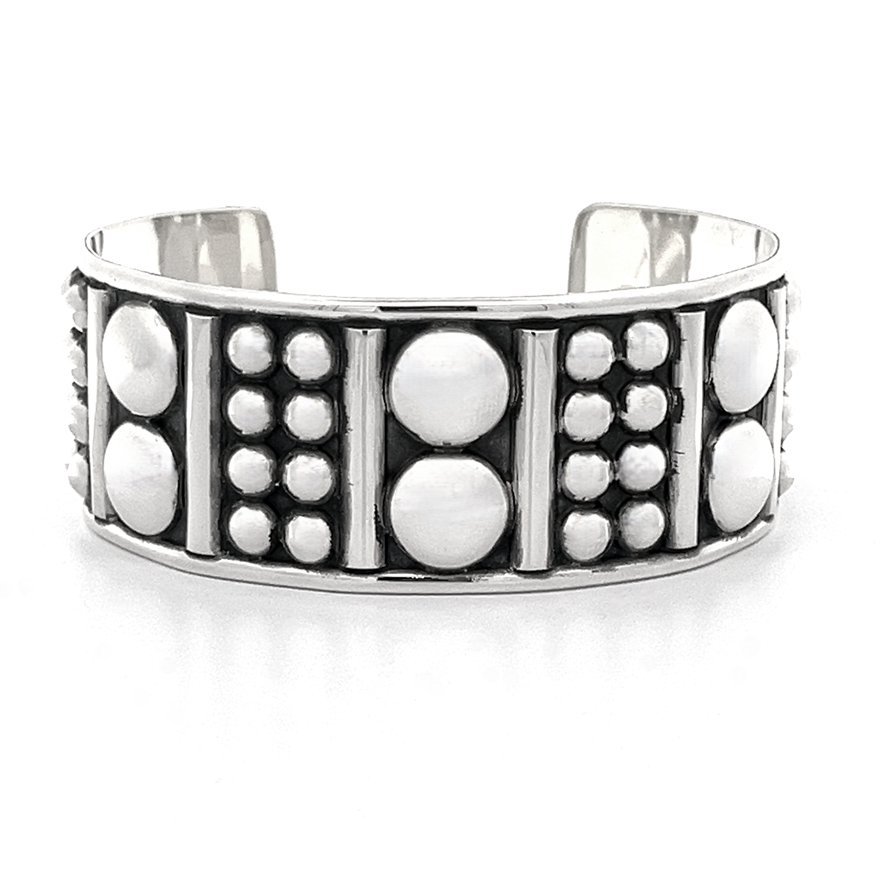 Introducing the Bold Ball Patterned Cuff: a sterling silver bracelet with an edgy design that features striking raised geometric patterns alongside a mix of large and small circular motifs.