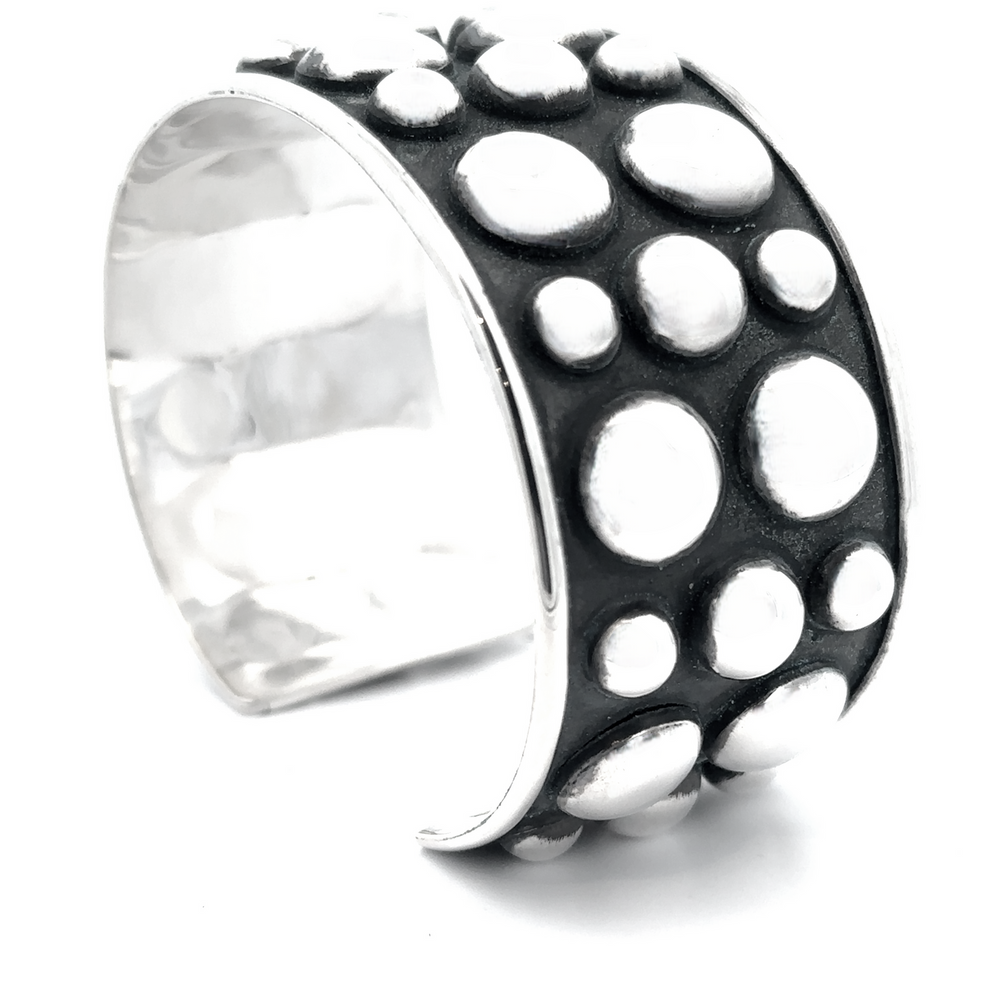 
                  
                    The Unique Ball Studded Cuff showcases a bold, rebellious design with raised bubble details on a contrasting black background, making it a true statement piece.
                  
                