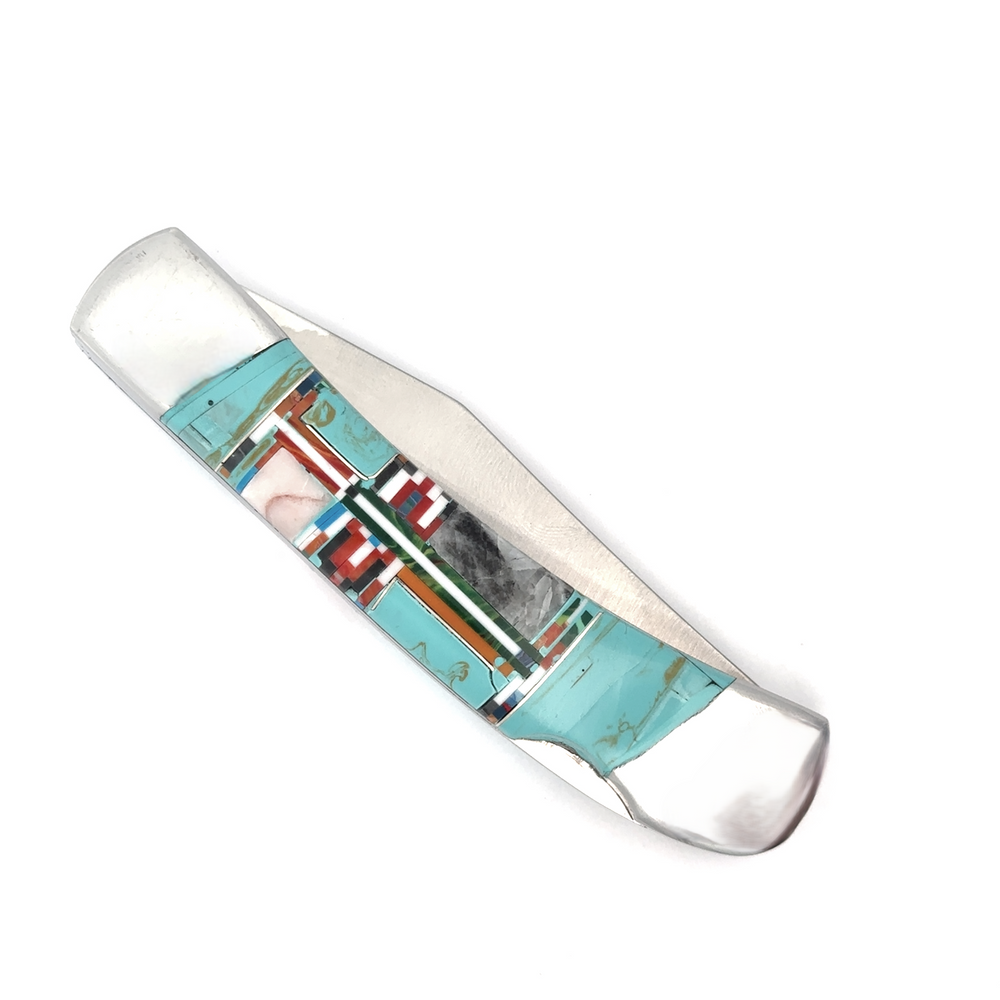 
                  
                    Introducing the Intricate Inlay Southwest Pocket Knife, adorned with striking geometric patterns featuring turquoise inlay, coral, and black elements.
                  
                