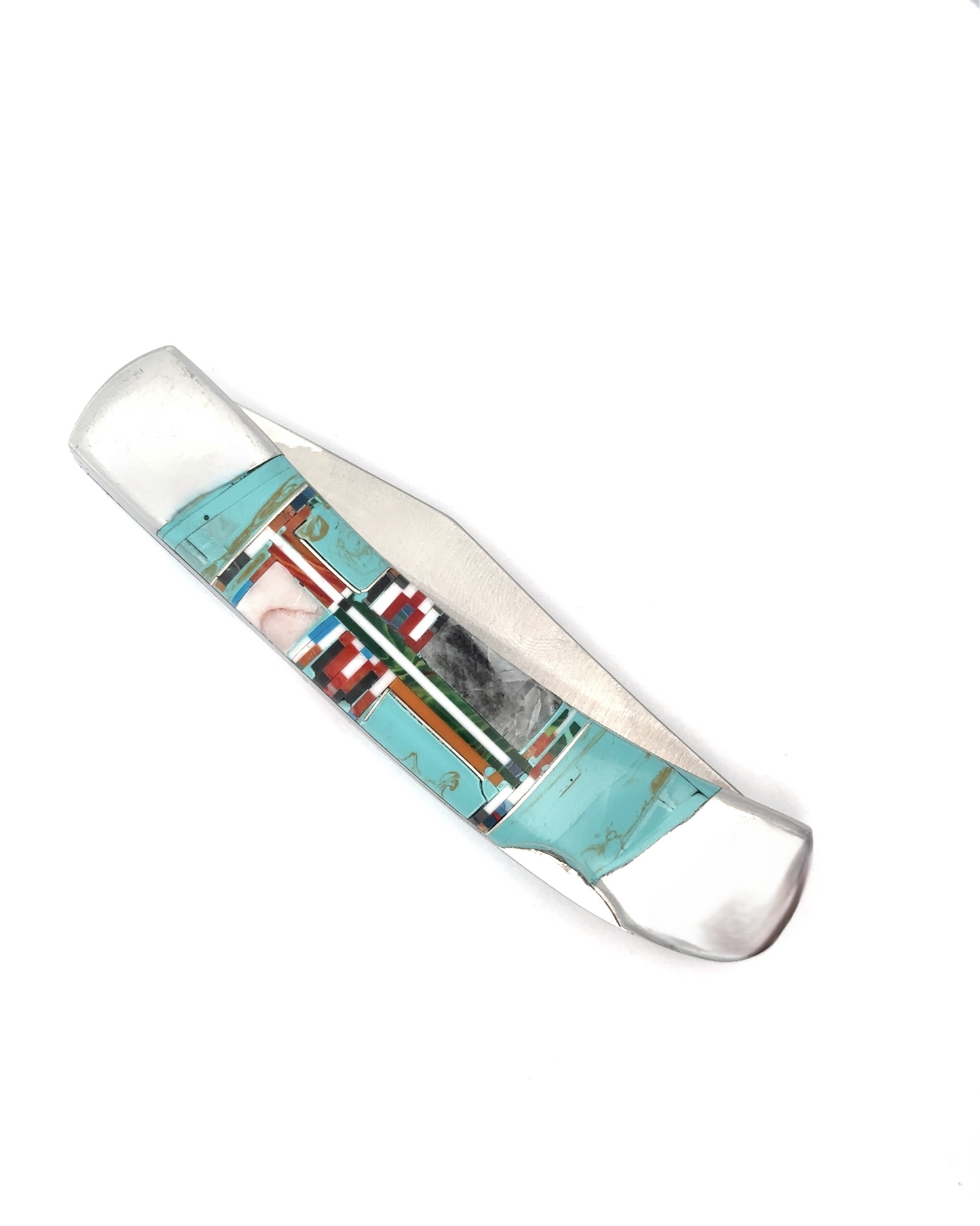 
                  
                    Introducing the Intricate Inlay Southwest Pocket Knife, adorned with striking geometric patterns featuring turquoise inlay, coral, and black elements.
                  
                