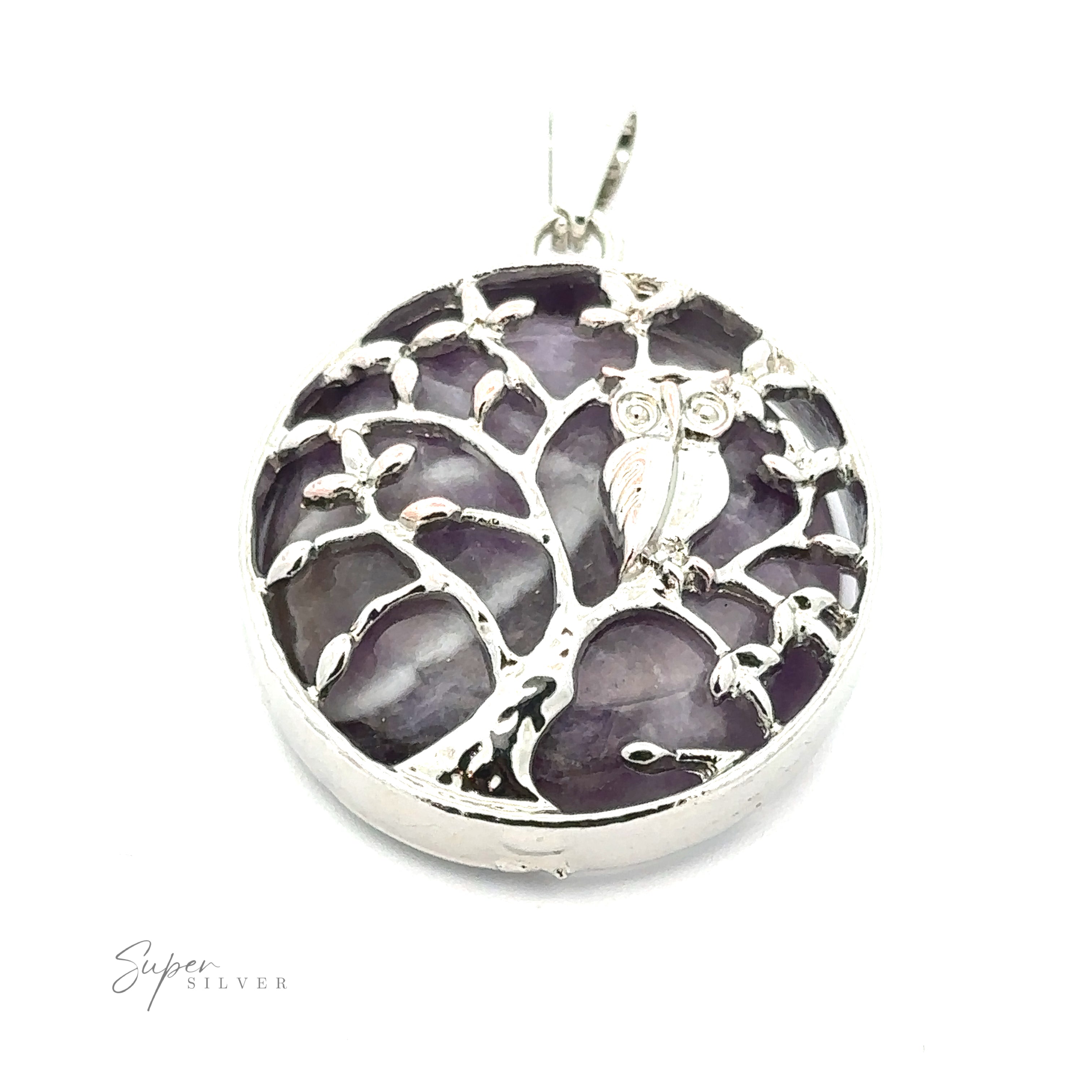 A circular silver pendant featuring a tree with an owl perched on its branch. The background of this exquisite Owl and Tree Pendant includes shimmering purple amethyst stones. The "Super Silver" logo is elegantly etched in one corner, adding a touch of distinction.