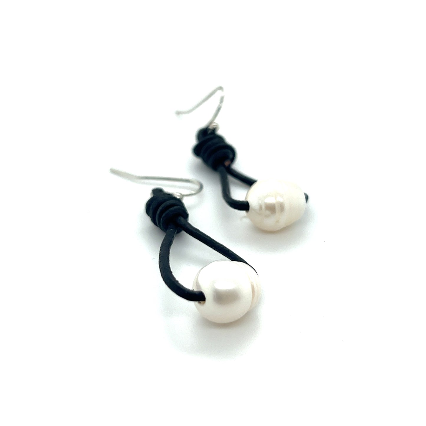 
                  
                    A pair of Super Silver Leather Cord and Pearl Earrings with a laid-back style on a white surface.
                  
                