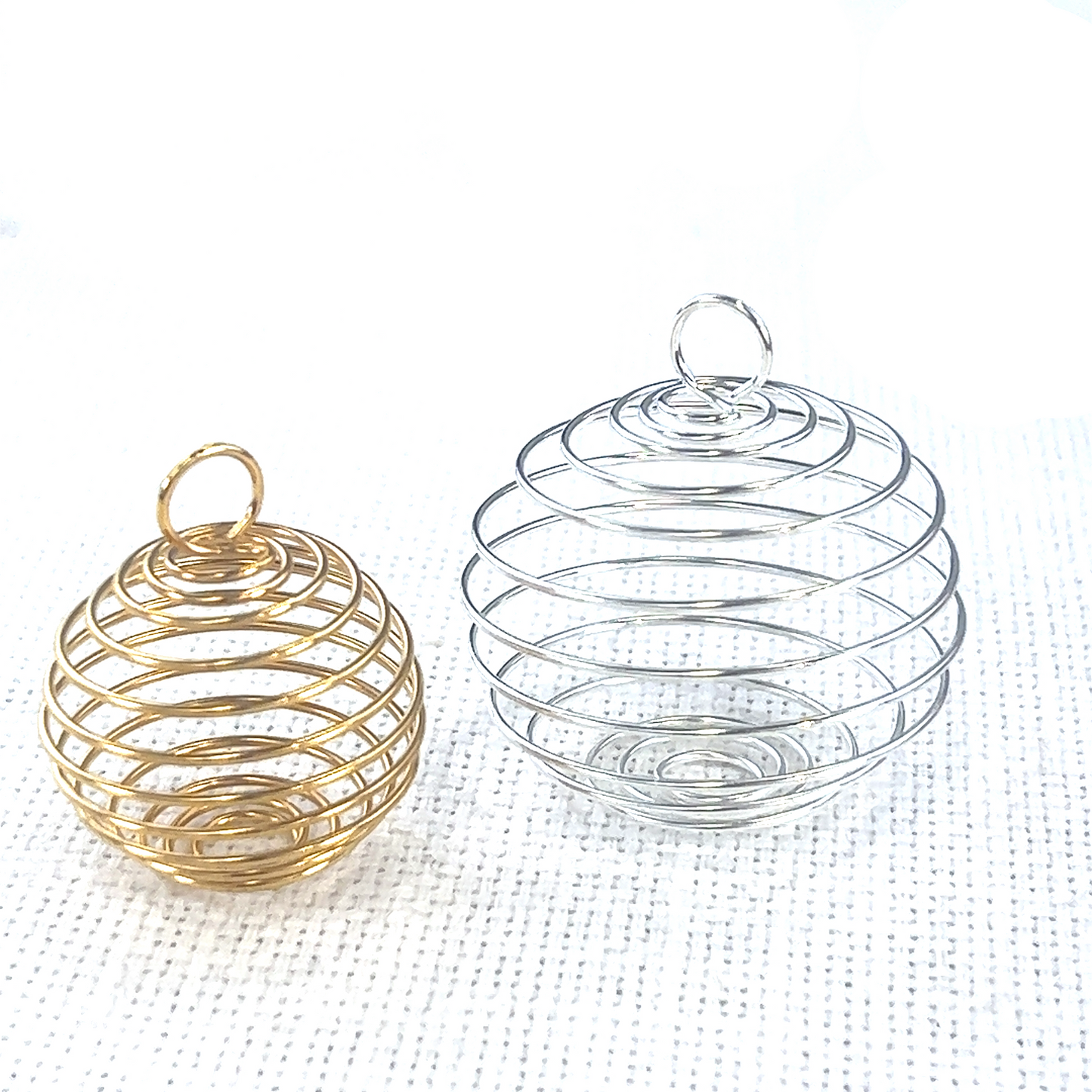 Two Super Silver Spiral Cage Pendant For Holding Gemstones on a white surface, perfect for charm enthusiasts.